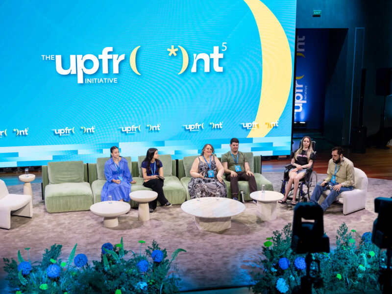 Πάνελ στο συνέδριο Upfront Initiative 2026. Καθισμένοι στο πάνελ από αριστερά η Στέλλα Τσουκαλά, η Ιωάννα Αναστασοπούλου, η Χρυσέλλα Λαγαρία, ο Γιάννης Βίτσος, η Μαρία Χατζηιωάννου και ο Θοδωρής Τσάτσος. Από πίσ μεγάλη οθόνη προβολής με το σήμα του Upfront.