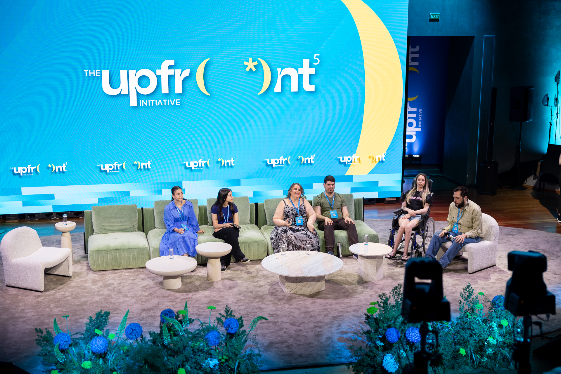 Πάνελ στο συνέδριο Upfront Initiative 2026. Καθισμένοι στο πάνελ από αριστερά η Στέλλα Τσουκαλά, η Ιωάννα Αναστασοπούλου, η Χρυσέλλα Λαγαρία, ο Γιάννης Βίτσος, η Μαρία Χατζηιωάννου και ο Θοδωρής Τσάτσος. Από πίσ μεγάλη οθόνη προβολής με το σήμα του Upfront.